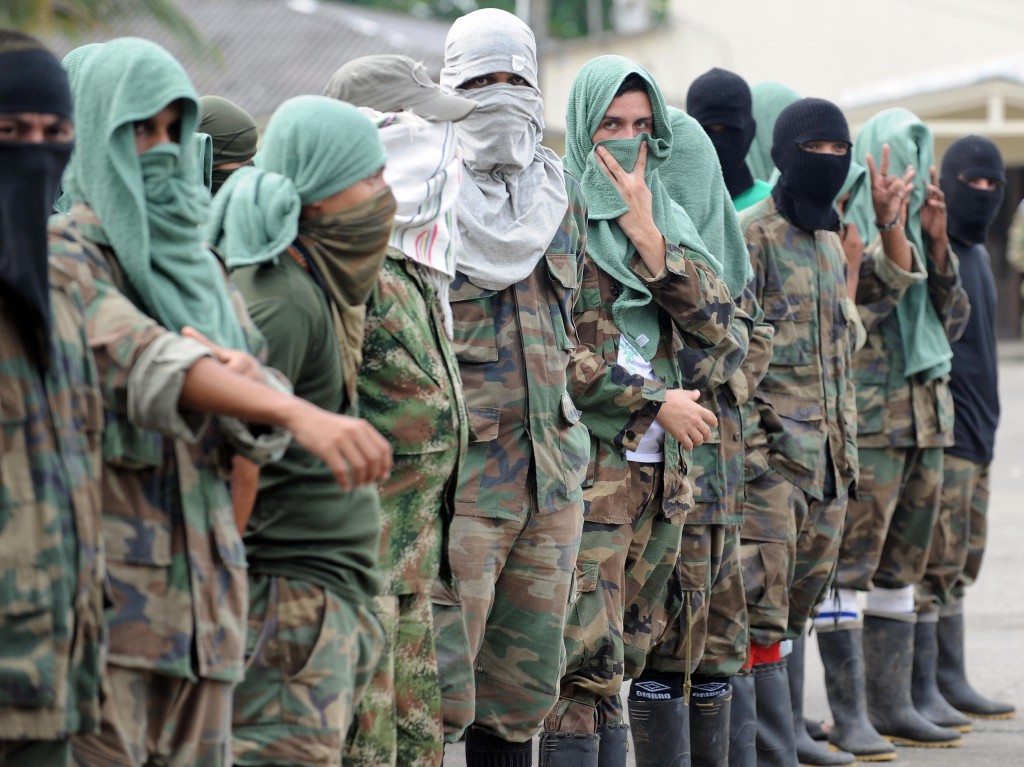 Members of "Los Rastrojos" bandit group cover their face with towels and balaclavas as they surrender at the Voltigeros Battalion on May 21, 2009 in Uraba, Antioquia department, Colombia.  112 members of "Los Rastrojos", a group of former AUC paramilitary right-wing guerrillas who became drug traffickers, have surrendered in Nuqui, Choco deparment, in the last days.   AFP PHOTO / Raul ARBOLEDA (Photo credit should read RAUL ARBOLEDA/AFP/Getty Images)