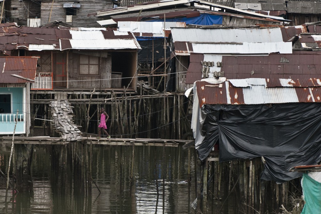 A girl walks between stilt houses in Buenaventura, Valle del Cauca department, Colombia, on March 25, 2014. Buenaventura, Colombia's main seaport on the Pacific coast, has been wreaked by a strong wave of violence for several months caused by disputes over the control of the region between criminal gangs, which ended up with the militarization of the area last week. In 2013 Buenaventura registered a rate of 49.6 homicides per 100 thousand inhabitants, above Colombia's average of 31 per 100 thousand, according to figures given by the Office of the Ombudsman. AFP PHOTO / LUIS ROBAYO