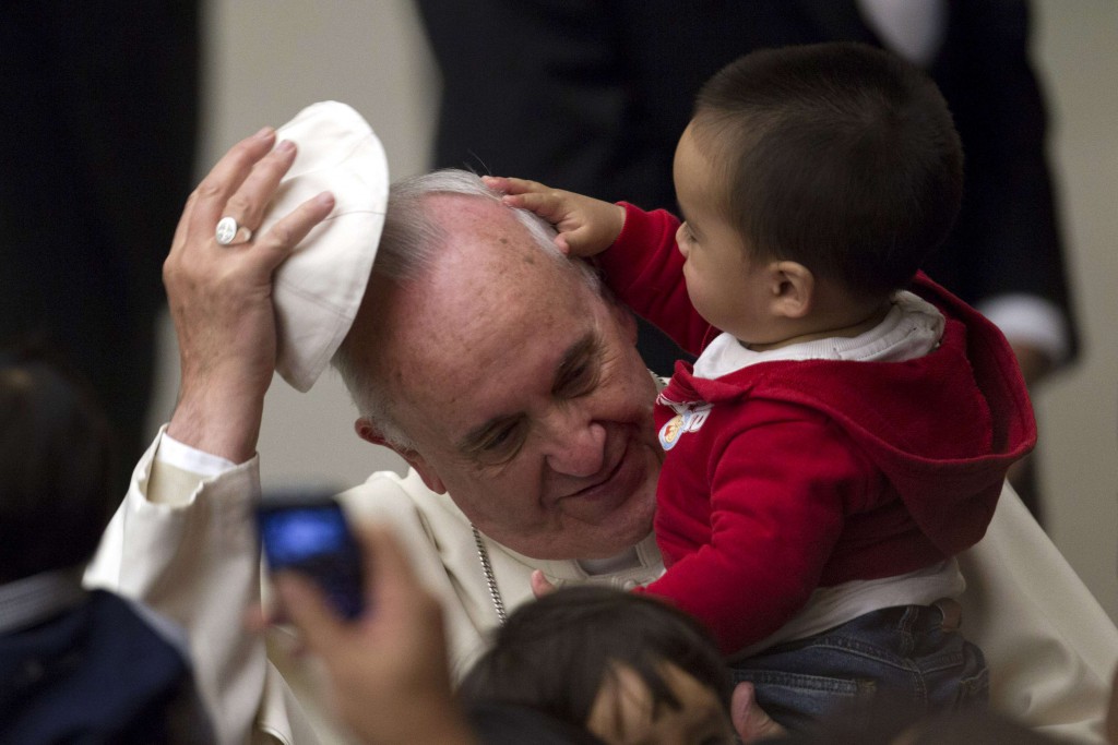 Pope Francis has his skull cap removed by a child during an audience with children assisted by volunteers of Santa Marta institute in Paul VI hall at the Vatican December 14, 2013. REUTERS/Giampiero Sposito (VATICAN - Tags: RELIGION TPX IMAGES OF THE DAY SOCIETY)