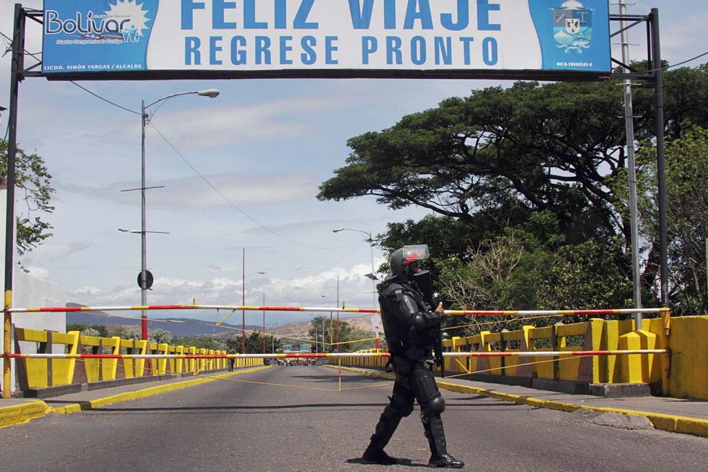 Venezuelan troops in riot gear stand by the Venezuela-Colombia border in San Antonio, Venezuela, on August 20, 2014. Venezuela's President Nicolas Maduro has ordered part of frontier with Colombia closed after four people were wounded in an overnight attack along the border.  AFP PHOTO/GEORGE CASTELLANO