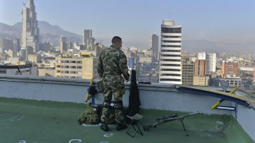 Un miembro de las Fuerzas Armadas, cumple labores de vigilancia, desde la terraza de un edificio en Bogotá. Foto: Efraín Herrera