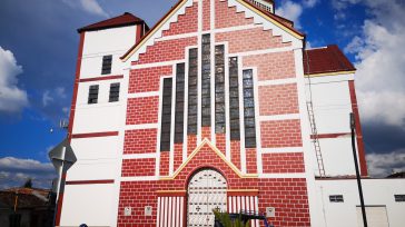 Iglesia principal de Palestina (Caldas), destacada por su fachada de ladrillo rojo y enmarques blancos, con una gran puerta central coronada por un arco. 